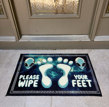 Doormat with alien design and text 'Please Wipe Your Feet' at a front door